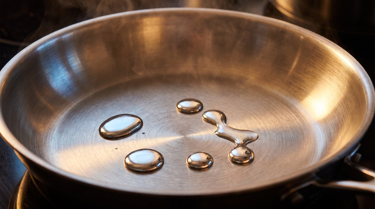 Water parelt als bolletjes over de bodem van een voorverwarmde roestvrijstalen koekenpan